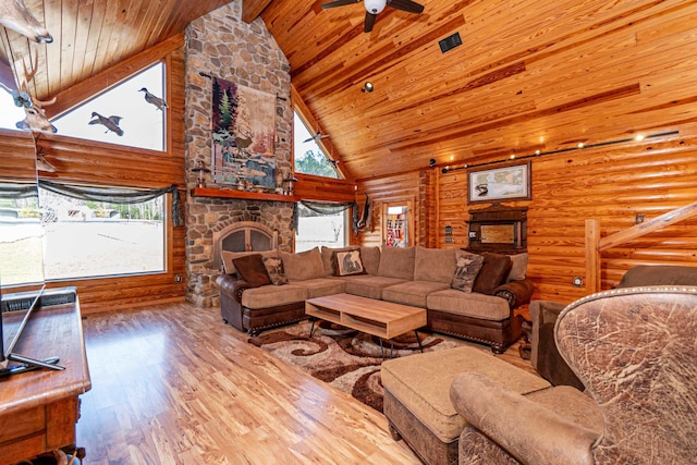 living room featuring log walls, a fireplace, high vaulted ceiling, and hardwood / wood-style flooring