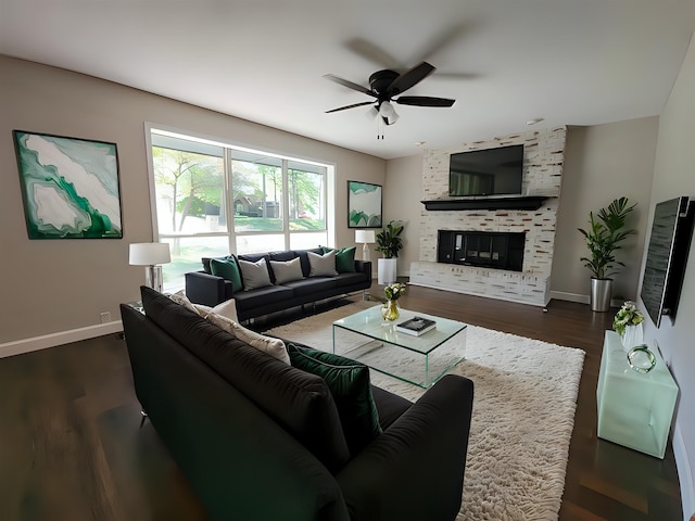 living room with a large fireplace, dark wood-type flooring, and ceiling fan