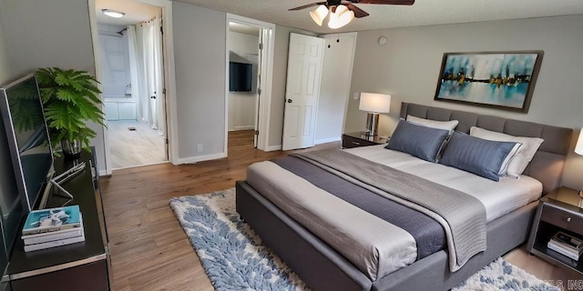 bedroom featuring ceiling fan, wood-type flooring, and ensuite bath