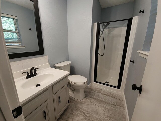 bathroom with vanity, toilet, and a shower with shower door