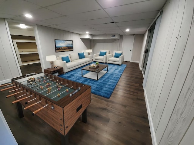 living room featuring dark wood-type flooring and a paneled ceiling