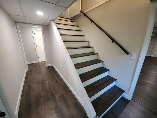 stairs with hardwood / wood-style flooring and a paneled ceiling