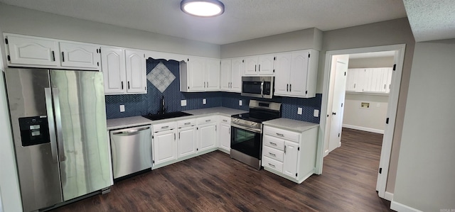 kitchen featuring stainless steel appliances, tasteful backsplash, sink, and white cabinets