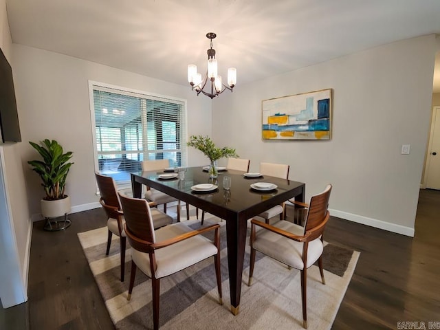 dining space featuring dark wood-type flooring and an inviting chandelier