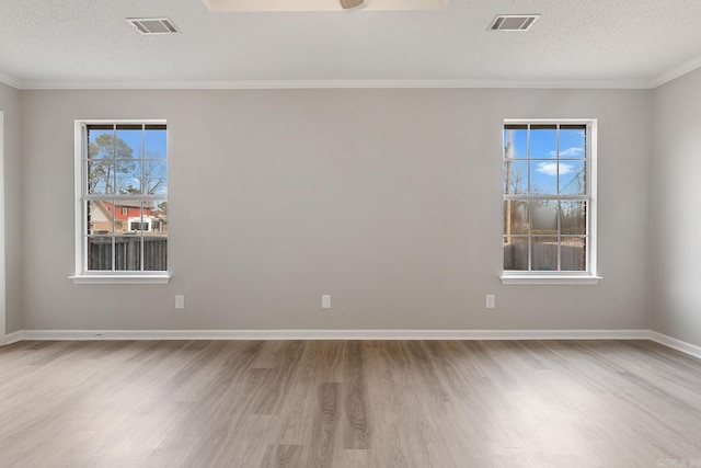 spare room featuring ornamental molding, ceiling fan, a textured ceiling, and light wood-type flooring