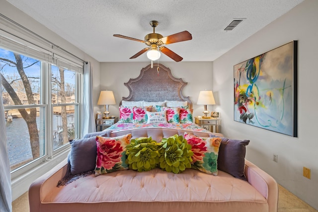 carpeted bedroom with a textured ceiling and ceiling fan