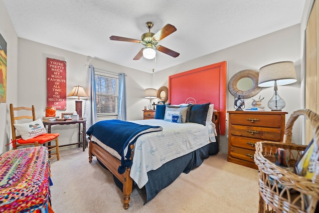 carpeted bedroom featuring a textured ceiling and ceiling fan