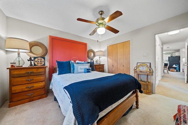 carpeted bedroom with a textured ceiling, a closet, and ceiling fan