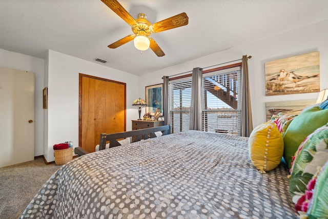 carpeted bedroom with ceiling fan and a closet