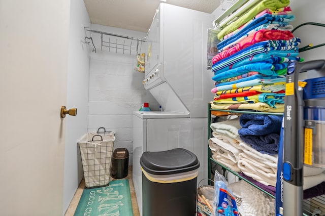 washroom with stacked washer / dryer and a textured ceiling