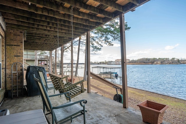 view of patio with a water view and a boat dock