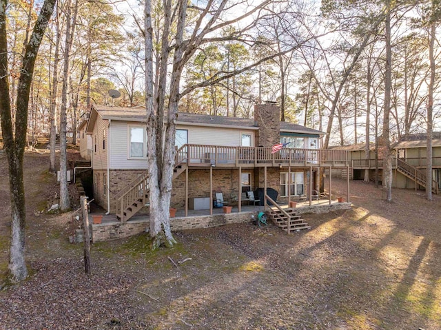 rear view of house with a wooden deck and a patio area