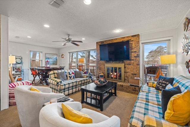 carpeted living room featuring a healthy amount of sunlight, a brick fireplace, and a textured ceiling