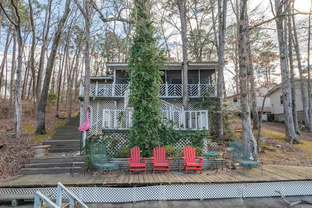 rear view of property with a sunroom and a deck