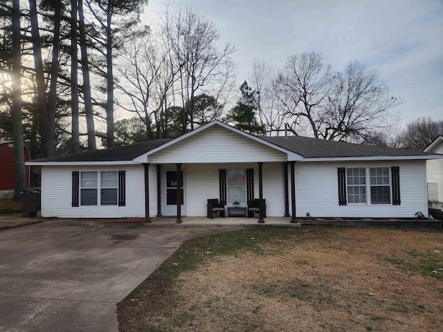 single story home with a porch and a lawn