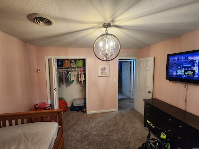 bedroom with visible vents, carpet, a textured ceiling, a chandelier, and a closet