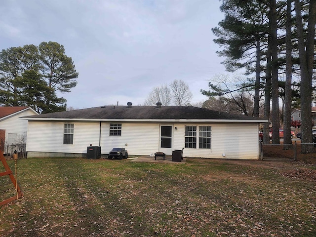 rear view of house featuring a lawn and central air condition unit