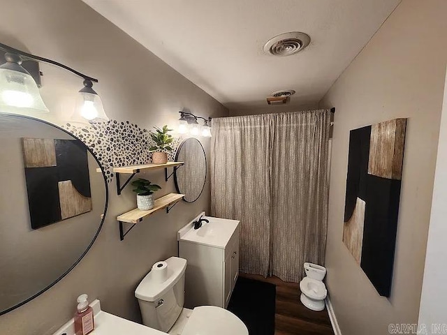 bathroom with toilet, a shower with shower curtain, wood finished floors, vanity, and visible vents