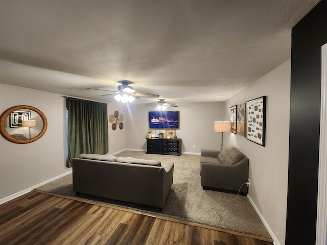 living room with ceiling fan, baseboards, and wood finished floors