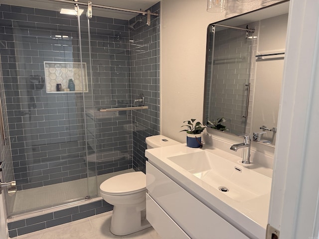 bathroom featuring vanity, a shower with shower door, tile patterned floors, and toilet