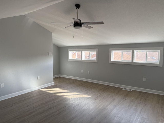 spare room featuring hardwood / wood-style flooring, vaulted ceiling, and ceiling fan