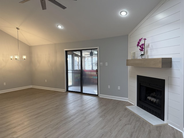 unfurnished living room featuring ceiling fan, a fireplace, vaulted ceiling, and hardwood / wood-style floors