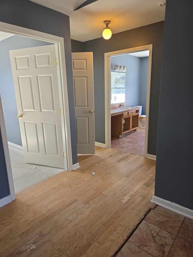 hallway with sink and hardwood / wood-style floors