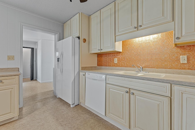 kitchen featuring sink, crown molding, white appliances, a textured ceiling, and cream cabinetry