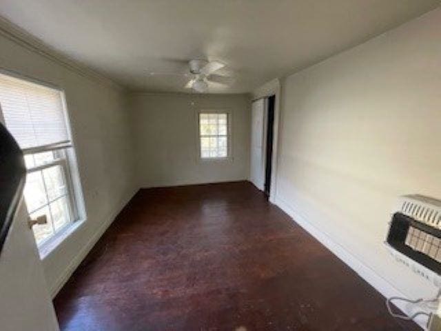 spare room featuring heating unit and ceiling fan