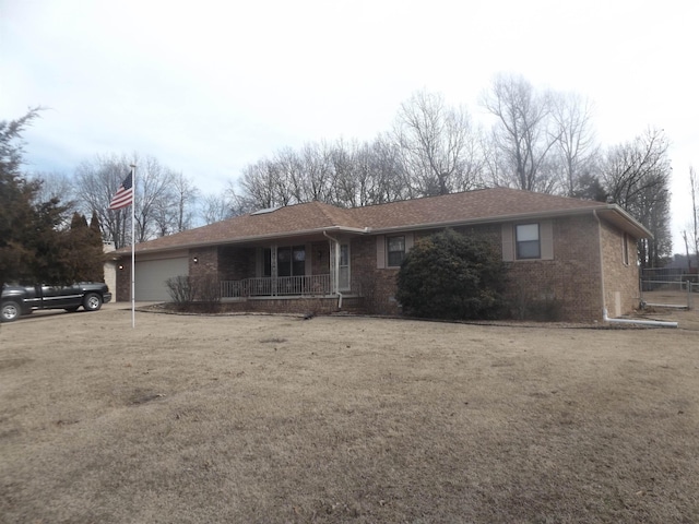 single story home with a garage, a porch, and a front lawn