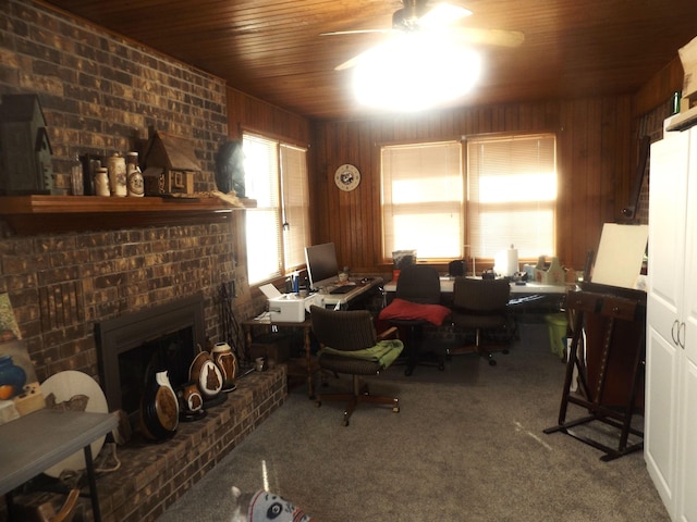 office area featuring wood walls, wooden ceiling, carpet flooring, ceiling fan, and a fireplace