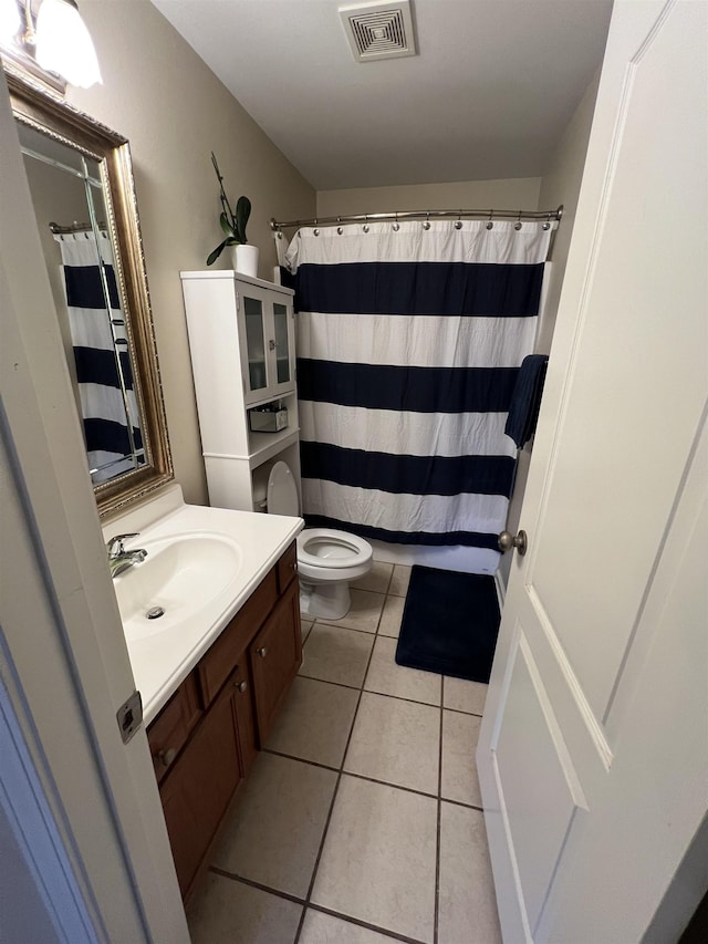 bathroom with tile patterned flooring, vanity, and toilet