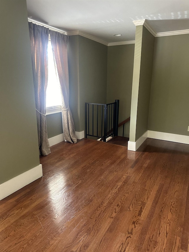 spare room featuring dark wood-type flooring and ornamental molding