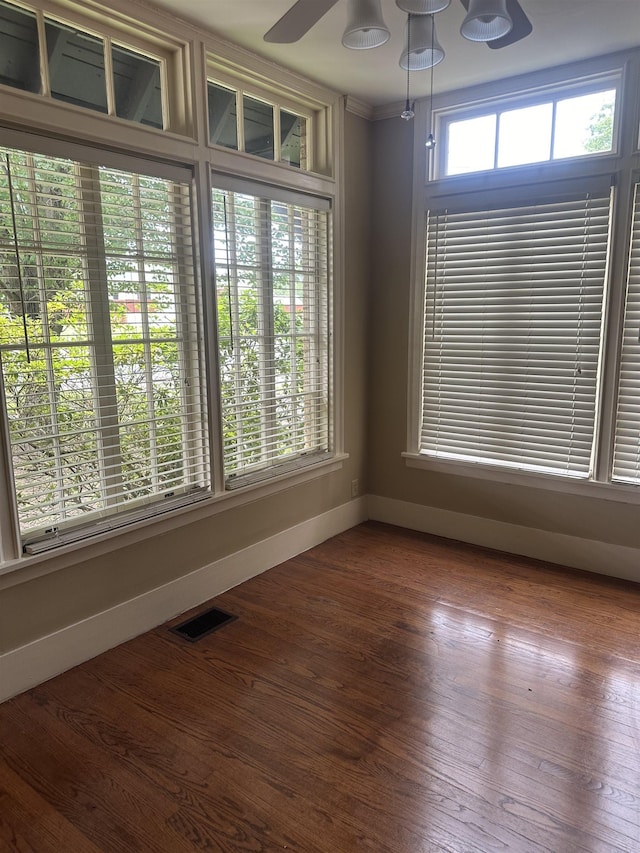 empty room featuring hardwood / wood-style flooring, ceiling fan, and a wealth of natural light