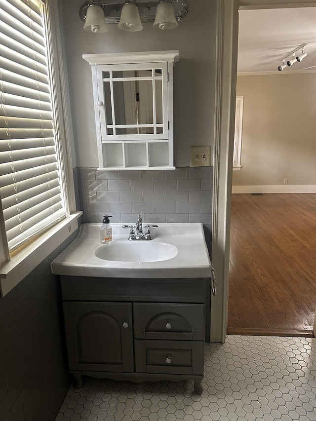 bathroom with tasteful backsplash, track lighting, vanity, and tile patterned flooring