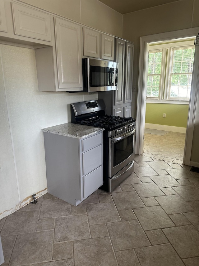 kitchen featuring white cabinetry, appliances with stainless steel finishes, and light stone countertops