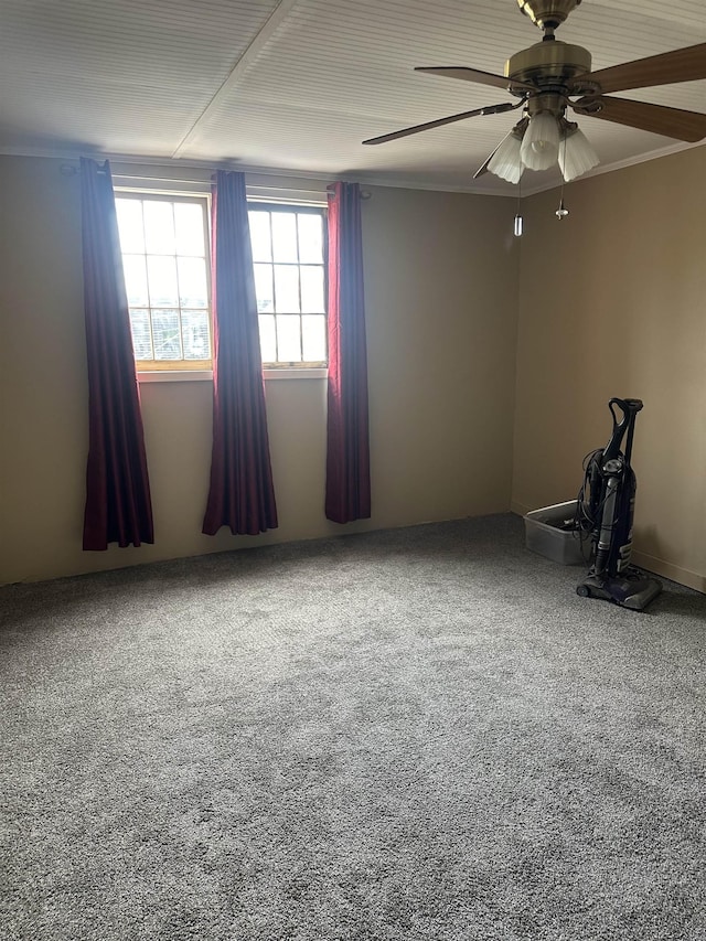 carpeted spare room featuring ceiling fan and ornamental molding