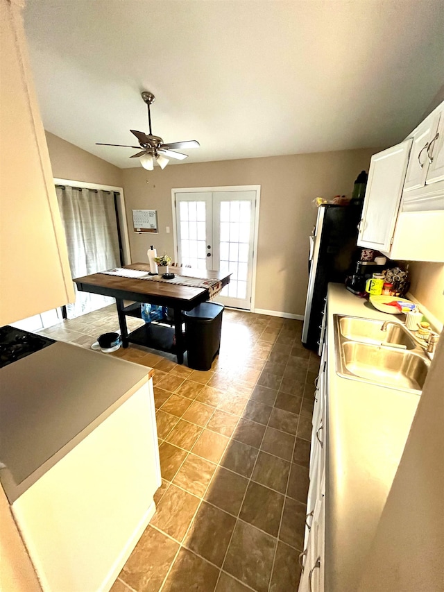 kitchen featuring french doors, sink, vaulted ceiling, dark tile patterned flooring, and white cabinets