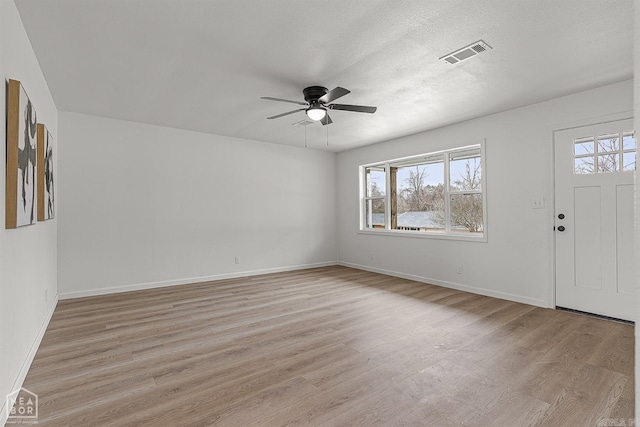 interior space featuring ceiling fan, a textured ceiling, and light wood-type flooring