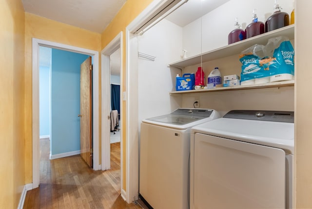 laundry area with light hardwood / wood-style flooring and independent washer and dryer