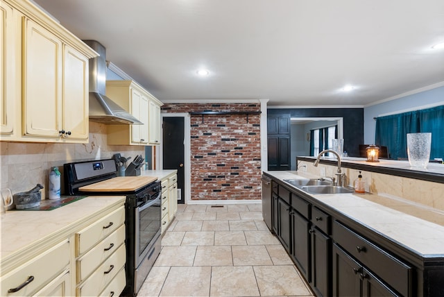 kitchen featuring wall chimney exhaust hood, sink, crown molding, stainless steel appliances, and cream cabinetry