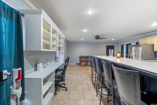 home office featuring crown molding, ceiling fan, and built in desk