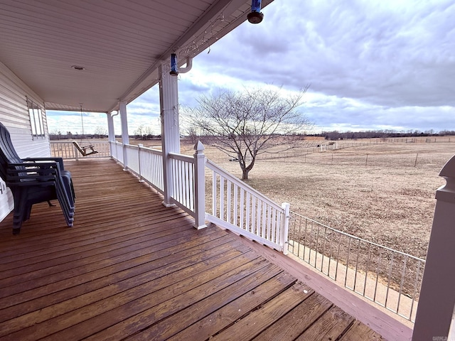 deck with a porch and a rural view