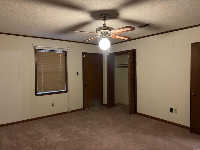 unfurnished bedroom featuring crown molding, a textured ceiling, ceiling fan, and carpet