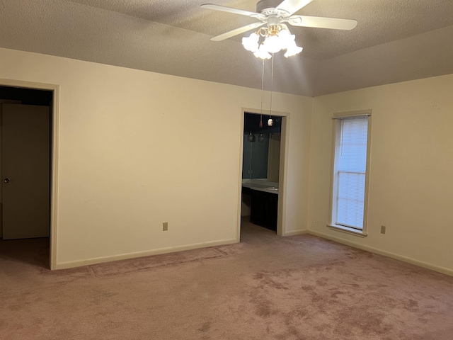 carpeted empty room with ceiling fan and a textured ceiling