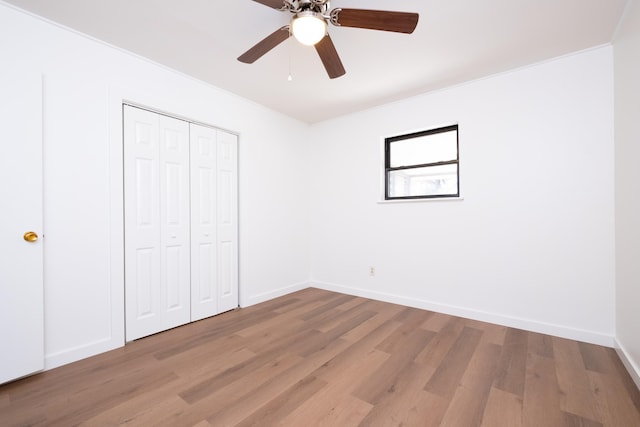 unfurnished bedroom featuring light hardwood / wood-style floors, ceiling fan, and a closet