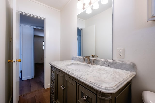 bathroom featuring hardwood / wood-style flooring, vanity, and crown molding