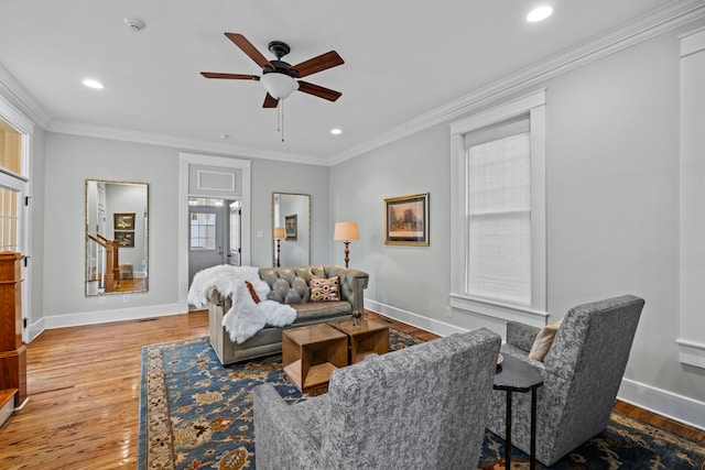 living room featuring ornamental molding, ceiling fan, and light wood-type flooring