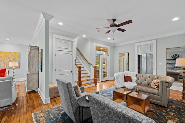 living room with hardwood / wood-style flooring, ornamental molding, and ceiling fan