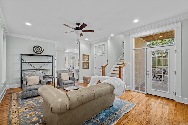 living room featuring crown molding, ceiling fan, and light wood-type flooring